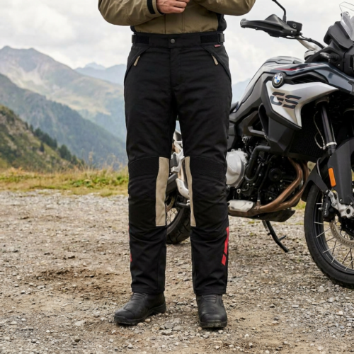 Motorrijder met zwarte BMW GS Puna GTX motorbroek naast een adventuremotor