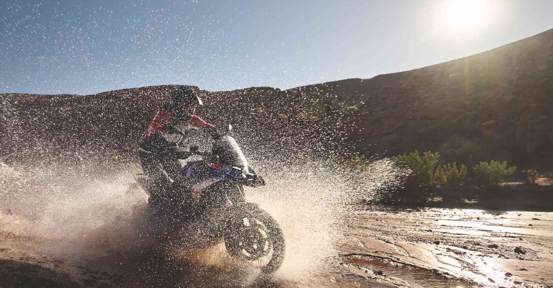 BMW GS rijdt door zonnig berglandschap tijdens warme zomerdag